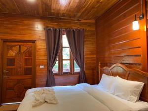 Ban OKonglor Cave Resort的木制客房的一张床位,设有窗户