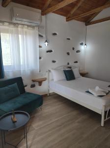 卡拉内拉Orange Garden Double Rooms的卧室配有白色的床和绿色沙发