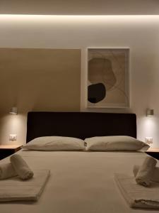 卡梅罗塔码头Marea Retreat Rooms的一间卧室配有一张大床和两个枕头