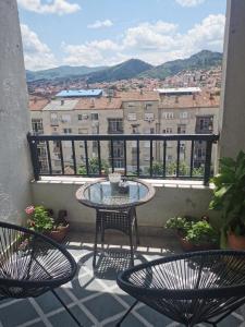 斯特鲁米察007 Apartments - TC Global, Strumica, Macedonia的阳台配有2把椅子和1张桌子,享有风景。
