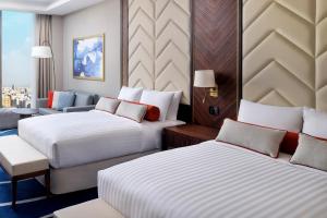 吉达Jeddah Marriott Hotel Madinah Road的酒店客房,设有两张床和一张沙发