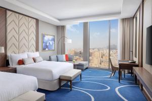 吉达Jeddah Marriott Hotel Madinah Road的酒店客房设有两张床和大窗户。