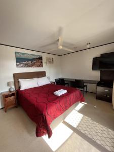 霍恩望盖海滩酒店的一间卧室配有一张带红色毯子的床