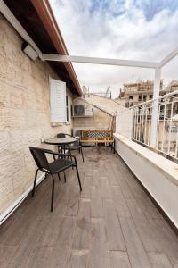 耶路撒冷ARISTO Machne Yehuda boutique apartments的阳台的天井配有桌椅