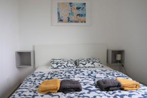 维尔Sea and rock的一间卧室配有一张床,上面有两条毛巾