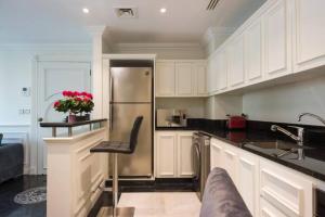 贝鲁特Versace Tower Luxury Suites - Downtown的厨房配有白色橱柜和不锈钢冰箱