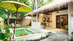 西塔努SandShine Village的一座带游泳池和黄色遮阳伞的房子