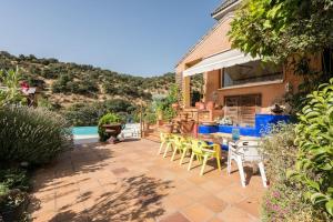 拉斯·罗萨斯·德·马德里Casa con vistas increíbles, piscina Infinity y jardín con rincones preciosos的一个带桌椅的庭院和一个游泳池