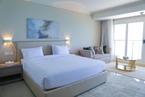 马特鲁港Triumph White Sands Hotel的一间带白色大床的卧室和一间客厅