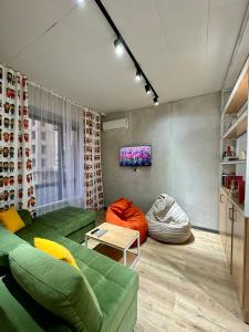 比什凯克izzzi hostel的客厅配有绿色沙发和电视