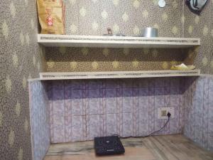 贾姆穆ASHIANA HOME STAY的一间设有水槽的房间,墙上有秤