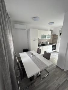 维尔Apartman Petra的小厨房配有白色的桌椅