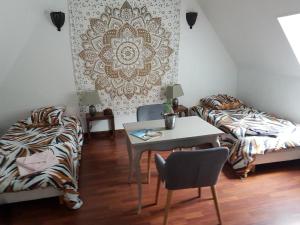 萨尔特河畔博蒙La belmontaise的客房设有桌子、床和桌椅。