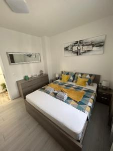 维尔Apartman Petra的一间卧室配有一张大床,提供黄色和蓝色的枕头