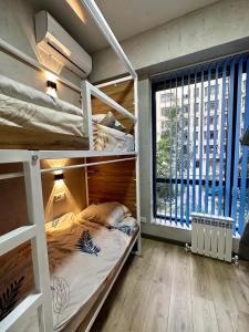 比什凯克izzzi hostel的一间卧室设有双层床和大窗户