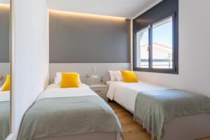卡斯特尔德费尔斯Precioso apartamento en la playa的带窗户的客房内的两张床
