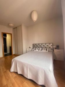 维戈Apartamento Pastora的一间卧室配有一张带白色床罩的大床