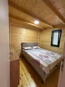 乌尔齐尼Sojenica Tamara的小木屋内一间卧室,配有一张床