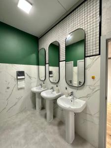 比什凯克izzzi hostel的浴室设有2个水槽和2面镜子
