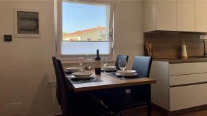 安卡兰Apartma Lima的餐桌,配有一瓶葡萄酒和玻璃杯