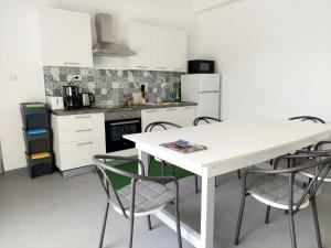 罗佐瓦克Rooms Ive的白色的厨房配有白色的桌子和椅子