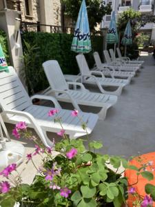 索佐波尔塔巴诺夫海滩酒店的一排带遮阳伞和鲜花的白色躺椅