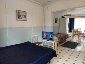 SimpeleLana Guest house的一间卧室配有一张床和一张桌子上的电视