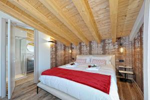 平佐洛Lux Domotic Apt-Chalet Dolomites的一间卧室设有一张带木制天花板的大床