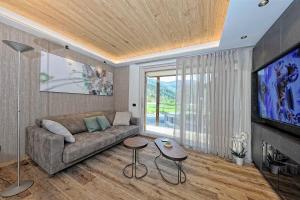 平佐洛Lux Domotic Apt-Chalet Dolomites的带沙发和平面电视的客厅