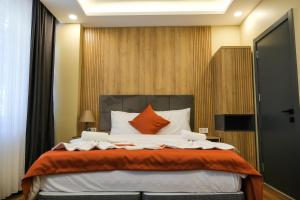 伊斯坦布尔hotel La Vitrine的一间卧室配有一张带橙色和白色枕头的大床