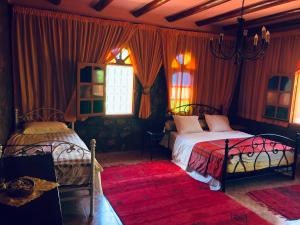 泰夫劳特Siliya rooms Heart Ameln Valley的一间卧室设有两张床和红色窗帘