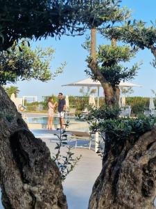 卡奥莱法提内罗酒店的站在游泳池旁的男人和女人