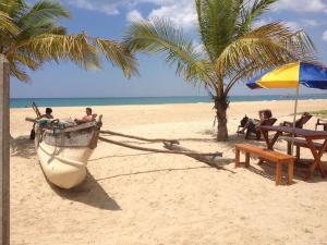 卡尔库达Aqua Marine Beach Hotel的海滩上的船,有人坐在长凳上