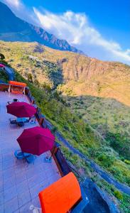 穆索里Doon Nature Valley Resort, Kempty Fall Mussoorie的山顶上一组带雨伞的桌子