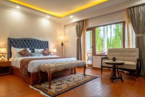 列城Hotel Gyalpo Residency - A Mountain View Luxury Hotel in Leh的卧室配有床、椅子和窗户。