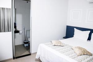 巴雷拉斯PARIS HOTEL的卧室配有白色的床和淋浴