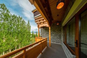 列城Hotel Gyalpo Residency - A Mountain View Luxury Hotel in Leh的阳台享有树林美景。