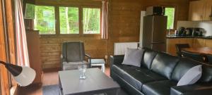 于尔克Vakantiepark 't Urkerbos - 5 persoons Brabantse blokhut的客厅配有沙发和桌子