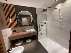 圣洛伦佐-迪塞巴托Residence Tantalus的带淋浴、盥洗盆和镜子的浴室