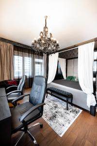 科希策Premium Apt Kosice Center 3 room with PARKING的一间卧室配有一张床、椅子和吊灯
