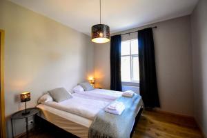 劳加尔瓦特恩Bjork Guesthouse的一间卧室配有一张带白色床单的床和一扇窗户。