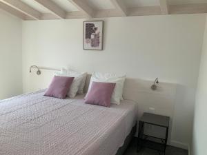 Quinta da Ema的一间卧室配有一张带两个紫色枕头的床