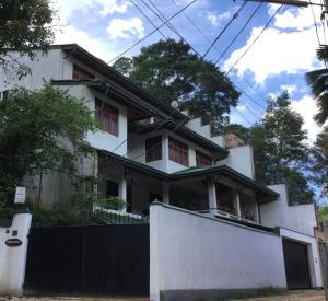 康提Reverie Hill Bungalow, Kandy的前面有栅栏的白色房子