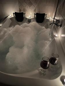 锡比乌La Mary in Old Town的装满雪的浴缸,装有两杯葡萄酒