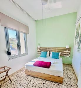 干尼亚Golden Key apartments的一间卧室配有一张带蓝色和红色枕头的大床