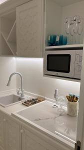 圣费利切-奇尔切奥AMAREA Exclusive Suites的白色的厨房配有水槽和微波炉
