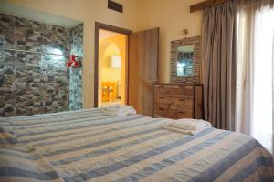 普拉坦斯卡泰里尼公寓酒店的一间卧室设有一张床和石墙