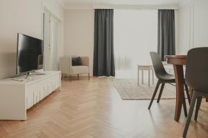 维也纳瑞典广场亥米公寓的客厅配有电视和桌椅