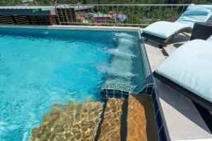 普吉镇Private Rooftop Pool - Penthouse的一个带蓝色水和两把椅子的游泳池