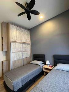 金马仑高原Lucky Home @ Quintet Tanah Rata的一间卧室配有两张床和吊扇